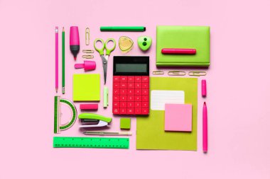 Pembe arka planda farklı kırtasiyeye sahip modern hesap makinesi