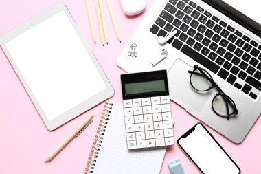 Pembe arka planda cihazları ve kırtasiyesi olan hesap makinesi