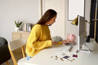 Evde para sayan genç bir kadın.