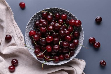 Gri arkaplanlı vişneli hasır kase.