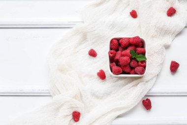 Taze ahududu ve hafif ahşap arka planda naneli kase.