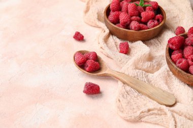 Taze ahududu ve bej arka planda kaşık dolu kaseler, yakın plan.