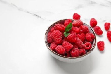 Taze ahududu ve nane arkaplanlı kase, yakın plan.