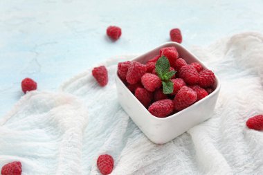 Taze ahududu ve nane arkaplanlı kase, yakın plan.