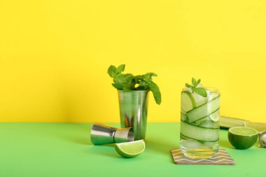 Bir bardak salatalıklı mojito barmen malzemeleriyle renklendirilmiş.
