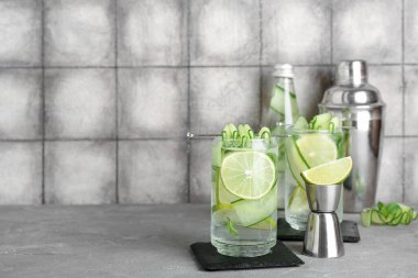 Grunge Grey masasında salatalıklı mojito bardakları