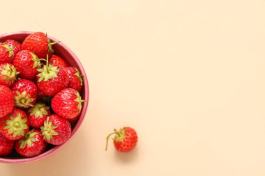 Bej arka planda taze çilekli kase, yakın plan.
