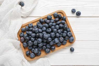 Hafif ahşap zemin üzerinde taze yaban mersini olan tahta.