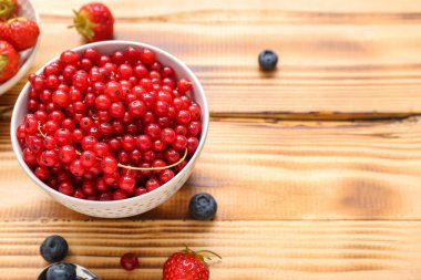 Taze üzümlü kase ve ahşap arka planda böğürtlen, yakın plan.