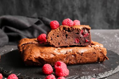 Siyah masanın üzerinde ahududulu çikolatalı browni var.
