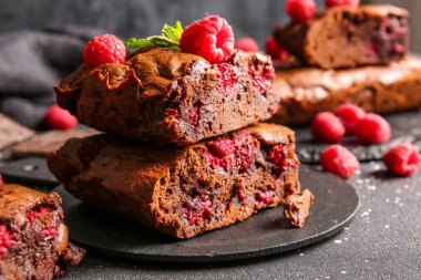 Siyah masanın üzerinde ahududulu çikolatalı browni var.