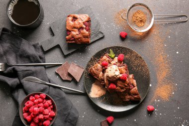 Siyah arka planda ahududulu çikolatalı browni tabağı.