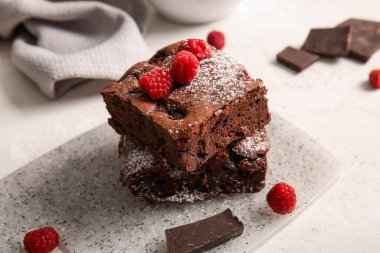 Beyaz arka planda ahududulu çikolatalı browni.