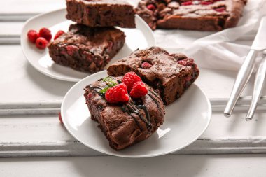 Beyaz arka planda ahududulu çikolatalı browni tabakları