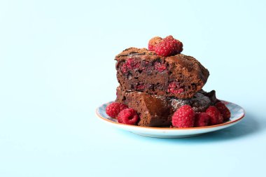 Mavi arka planda ahududulu çikolatalı browni tabağı.