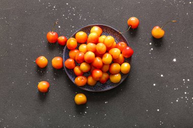 Siyah arka planda sarı kirazlı tatlı bir tabak