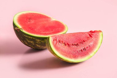 Pembe arkaplanlı taze karpuzun yarısı.