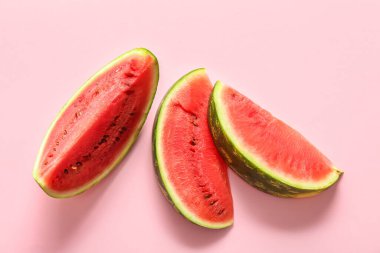 Pembe arka planda taze karpuz parçaları.
