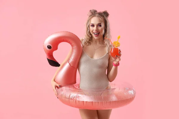 Młoda Kobieta Stroju Kąpielowym Nadmuchiwanym Pierścieniem Koktajlem Różowym Tle — Zdjęcie stockowe