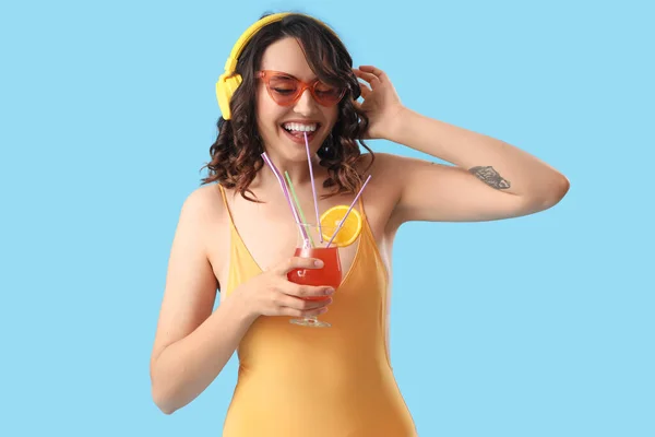Junge Frau Badeanzug Mit Kopfhörer Und Cocktail Auf Blauem Hintergrund — Stockfoto