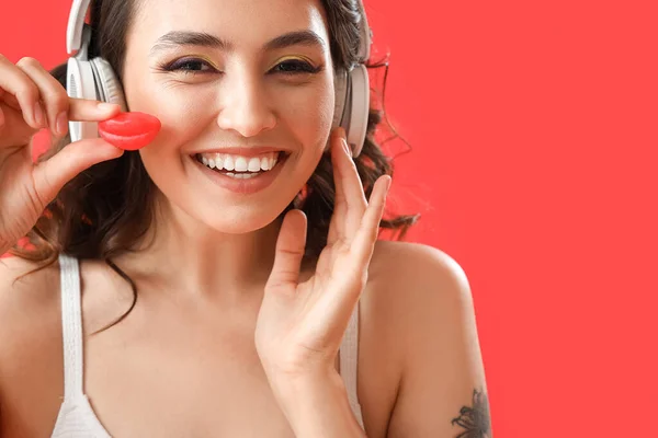 Mujer Joven Auriculares Con Dulces Sobre Fondo Rojo Primer Plano — Foto de Stock