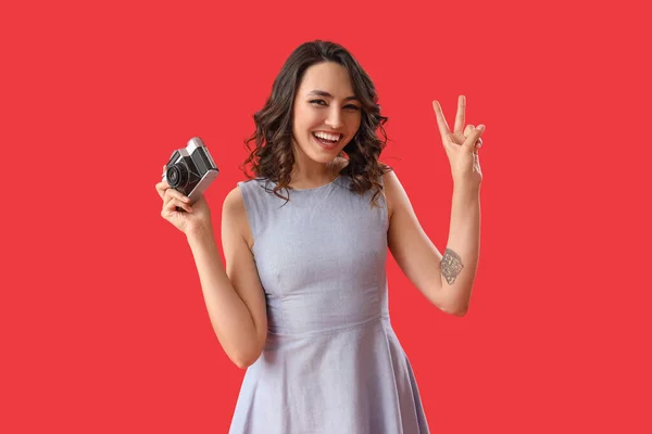 Νεαρή Γυναίκα Φωτογραφική Μηχανή Που Δείχνει Χειρονομία Νίκης Στο Κόκκινο — Φωτογραφία Αρχείου