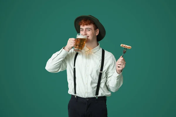 Νεαρός Άνδρας Παραδοσιακά Γερμανικά Ρούχα Λουκάνικο Πίνοντας Μπύρα Πράσινο Φόντο — Φωτογραφία Αρχείου