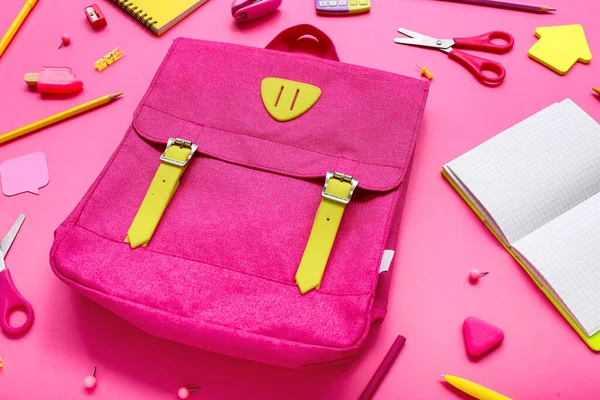 带有空白笔记本电脑和粉色背景的不同文具的背包 — 图库照片