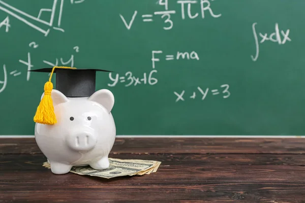 Sparschwein Zipfelmütze Mit Dollarnoten Auf Braunem Holztisch Vor Schultafel Konzept — Stockfoto