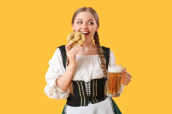 黄色の背景にビールとプレッツェルと美しい10月の祭典のウェイトレス — ストック写真