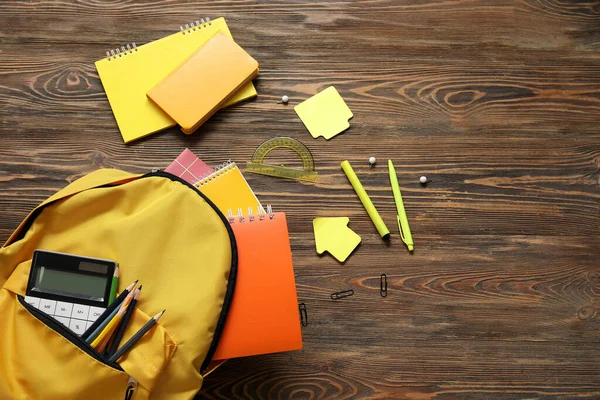 Yellow Σχολική Τσάντα Πλάτης Σημειωματάρια Αριθμομηχανή Και Μολύβια Καφέ Ξύλινο — Φωτογραφία Αρχείου