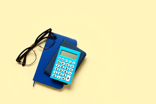 Modern Calculator Eyeglasses Notebooks Pale Yellow Background — Stock Photo, Image