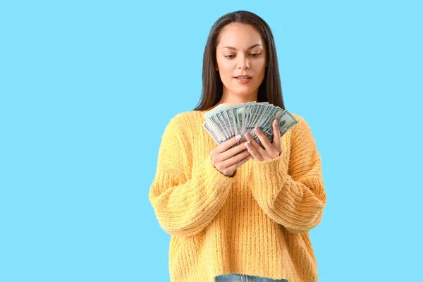 Mavi Arka Planda Dolar Banknotları Olan Genç Bir Kadın — Stok fotoğraf