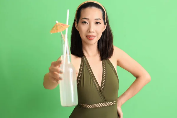 Красивая Азиатка Купальнике Бутылкой Лимонада Зеленом Фоне — стоковое фото