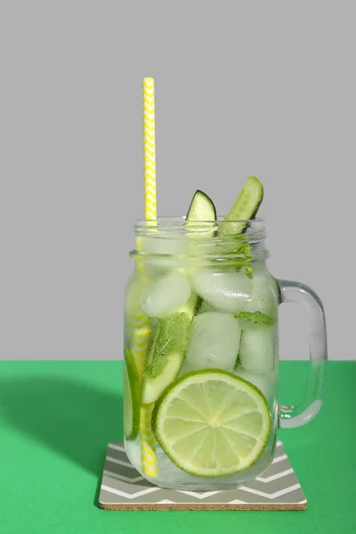 莫吉托鸡尾酒配上黄瓜 石灰和冰块 放在绿色背景的玻璃瓶中 — 图库照片