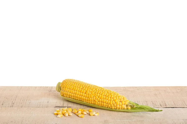 浅色木制桌子上的新鲜玉米芯和种子 背景为白色 — 图库照片