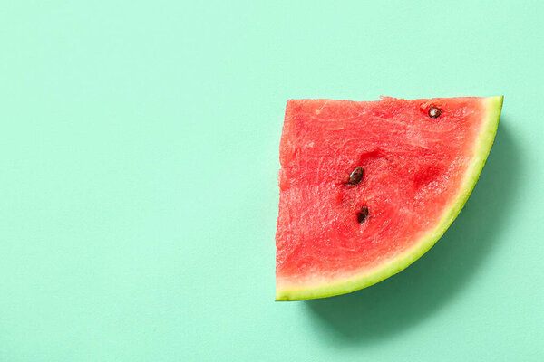 Piece of fresh watermelon on turquoise background