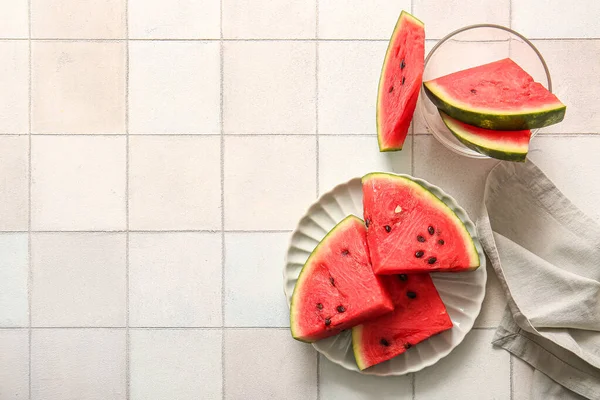 stock image Plate and bowl with pieces of fresh watermelon on white tile table