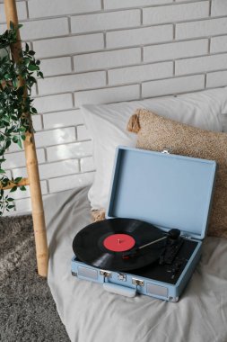 Yatakta vinil diski olan kayıt çalar