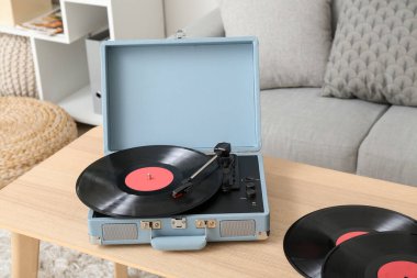 Oturma odasındaki masada vinil disklerle müzik çalar