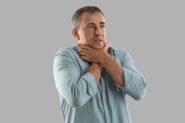 Olgun bir adam arka planda panik atak geçiriyor.