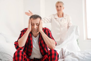 Stresli olgun bir adam ve kavgacı karısı yatak odasındalar.