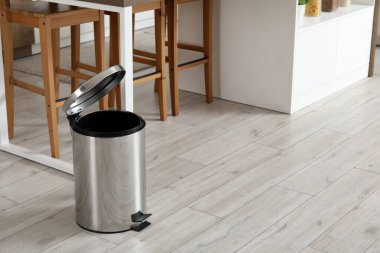 Mutfağın içindeki çöp kutusunu açtı.