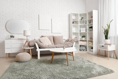 Oturma odasının içinde kanepe, sehpa ve ayna var.