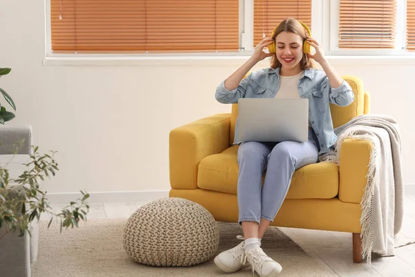 Young Woman Headphones Laptop Sitting Yellow Armchair Home — Fotografia de Stock