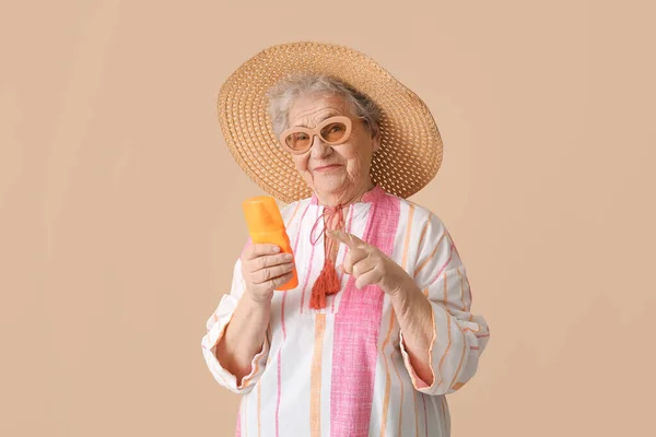 Senior Woman Pointing Sunscreen Cream Beige Background — Stock Photo, Image