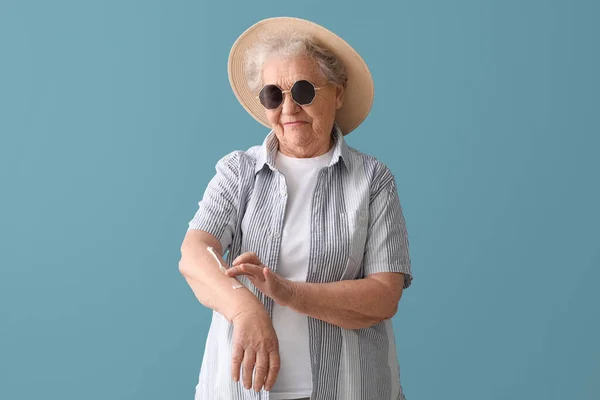 Senior Mulher Aplicando Protetor Solar Creme Fundo Azul — Fotografia de Stock