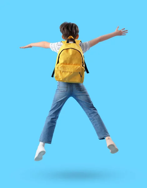 Jumping Μικρό Αγόρι Σχολική Τσάντα Μπλε Φόντο Πίσω Όψη — Φωτογραφία Αρχείου