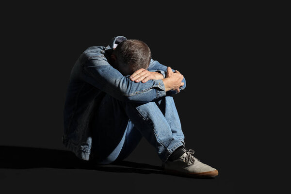 Mature man having panic attack on black background