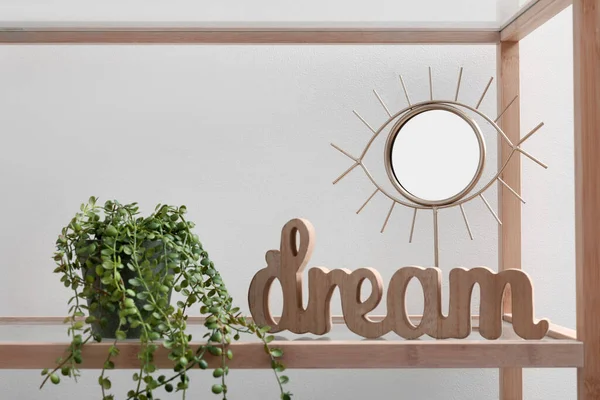 stock image Shelving unit with mirror and houseplant near white wall, closeup